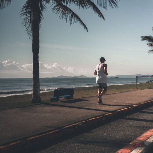 Man demonstrating a core strengthening exercise outdoors at sunrise.